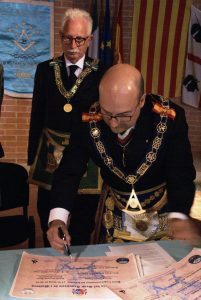 Il Gran Maestro Ortega firma la carta del gemellaggio. Alle sue spalle, il Gran Segretario Pietrangeli